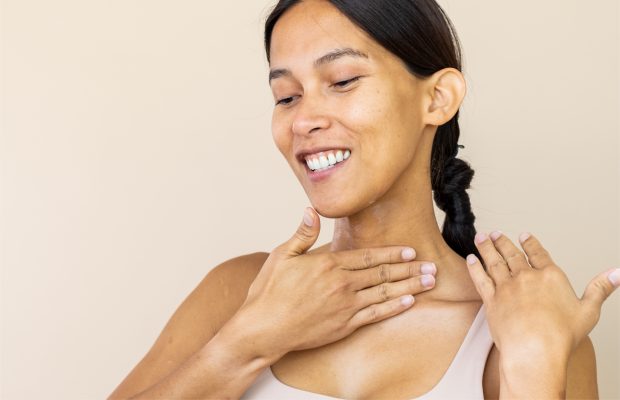 a woman doing skincare on her neck