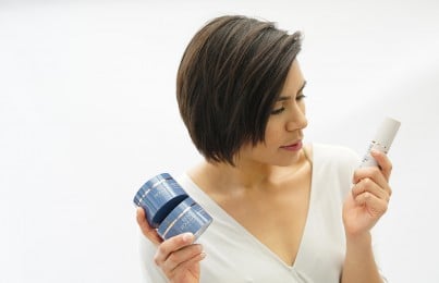 a woman looking at the label of Renee Rouleau products