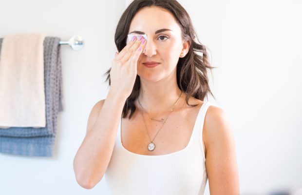 a woman removing eye makeup