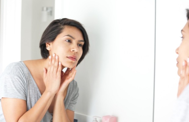 a woman checking her face in the mirror