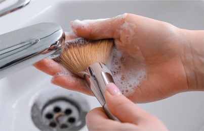 a makeup brush being cleaned with the use of Renee Rouleau face cleanser