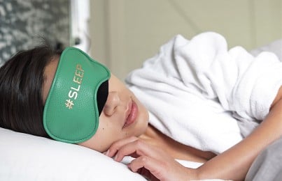 a woman sleeping with an eye mask on