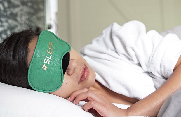 a woman sleeping with an eye mask on