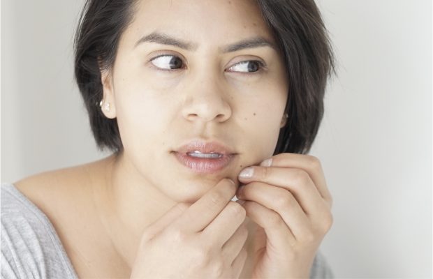 a woman picking at her skin