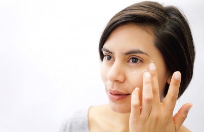 a woman touching her eye wrinkles