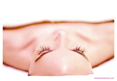 a woman laying with a towel on her body