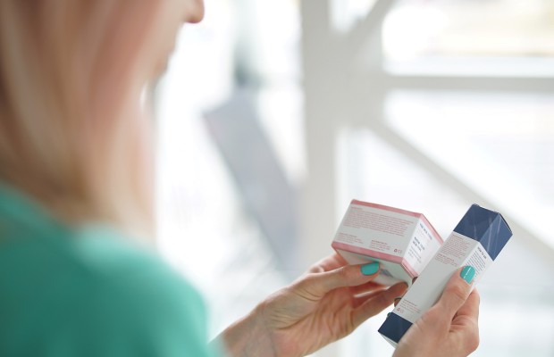 a woman looking at the skincare product labels