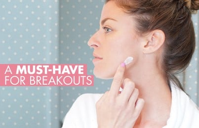 a woman applying cream on her blemish