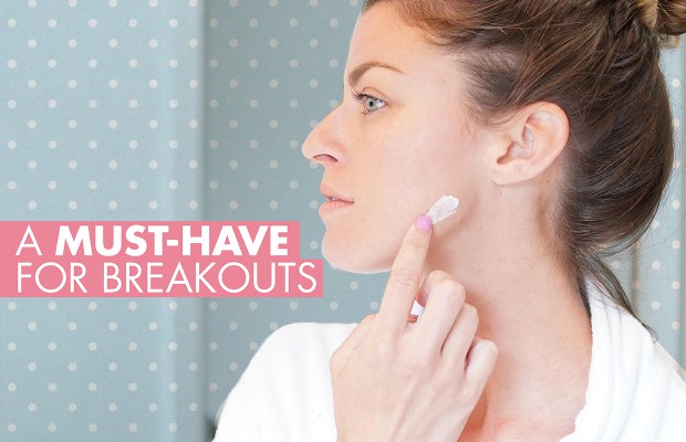 a woman applying cream on her blemish