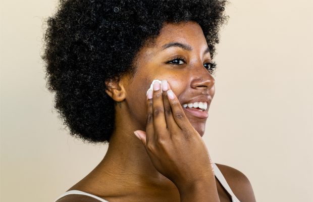 a woman applying Renee Rouleau skincare products on her acne