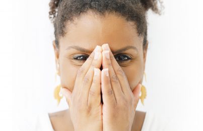 a woman covering her nose with her hands