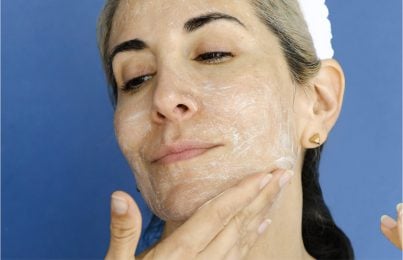 a woman moisturizing her face