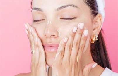 a woman putting cream on her face