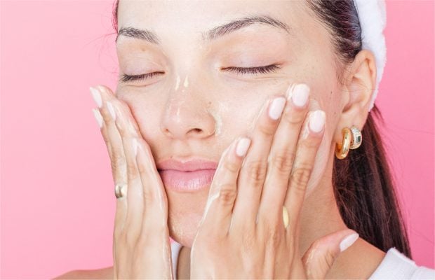 a woman putting cream on her face