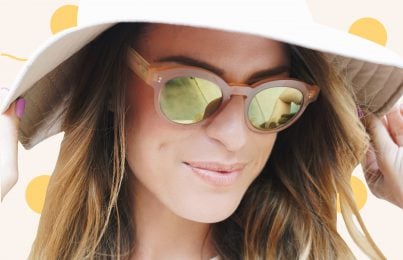 a woman wearing glasses and a hat to avoid sun spots