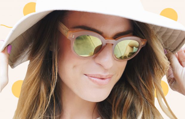 a woman wearing glasses and a hat to avoid sun spots