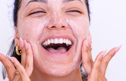 a woman happily scrubbing her face
