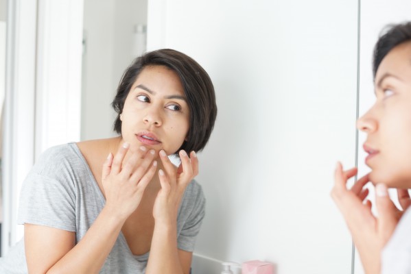 a woman popping her pimple