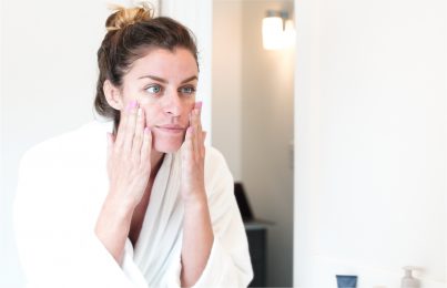 woman touching her skin Infront of the mirror