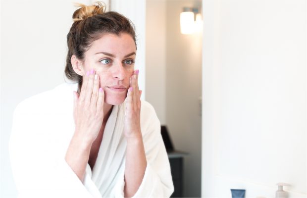 woman touching her skin Infront of the mirror