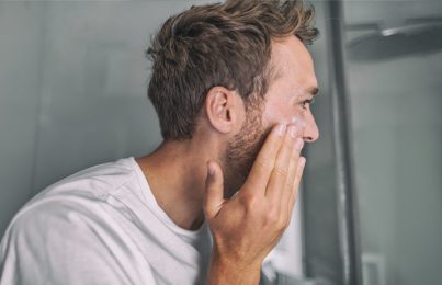 Man applying skincare products on his face