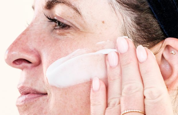 woman applying silicon containing cream on her face