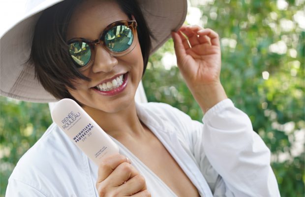 a woman holding the Renee Rouleau Weightless protection sunscreen