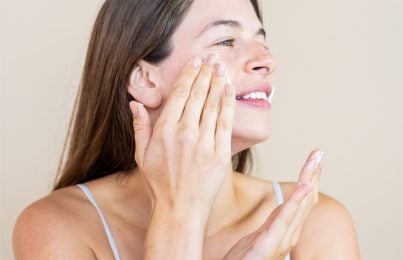 woman applying a skin care product on her face