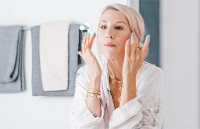 Renee Rouleau applying skincare products to her face