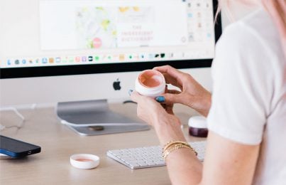 Woman at computer testing skincare product formula