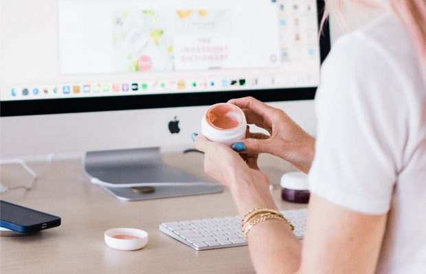 Woman at computer testing skincare product formula