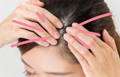 a woman touching her scalp