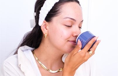 a girl sniffing the fragrance of her skincare product