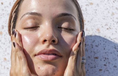 a woman with glowing skin standing in the sun