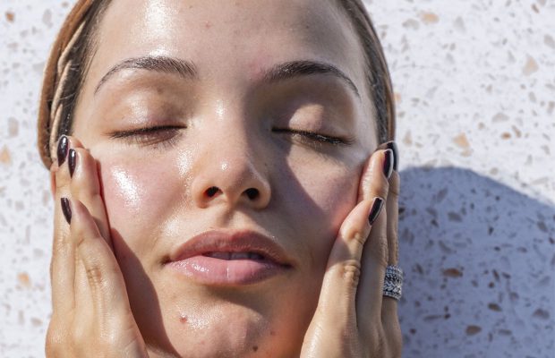 a woman with glowing skin standing in the sun