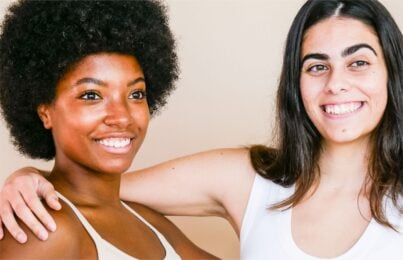 two women can be seen standing with each other in a friendly manner